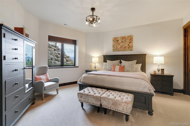 carpeted bedroom featuring a notable chandelier