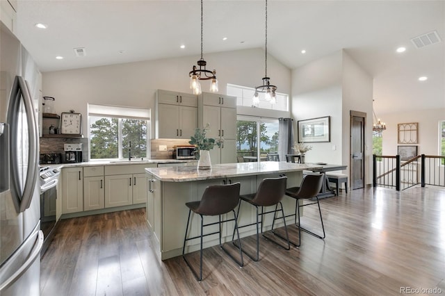 kitchen featuring a healthy amount of sunlight, wood-type flooring, a center island, and stainless steel appliances