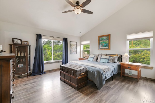 bedroom with ceiling fan, high vaulted ceiling, and light wood-type flooring