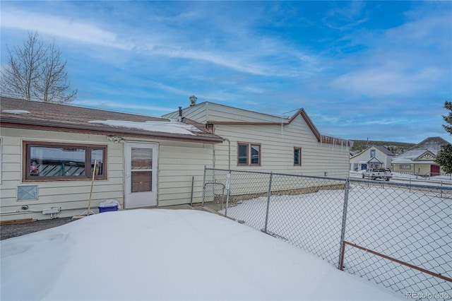 view of snow covered rear of property