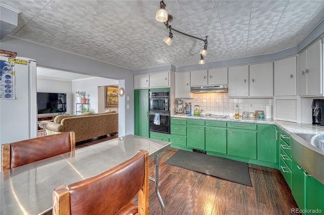 kitchen featuring tasteful backsplash, black appliances, dark hardwood / wood-style floors, and green cabinetry