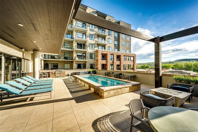 view of pool featuring a patio area, a hot tub, and an outdoor fire pit