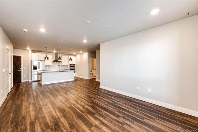 unfurnished living room featuring dark hardwood / wood-style flooring and sink