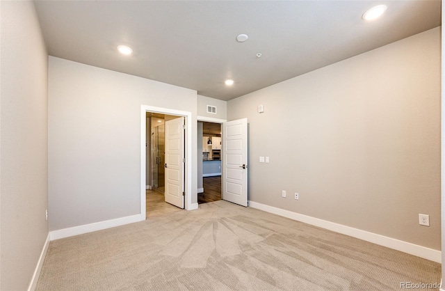 unfurnished bedroom featuring light carpet