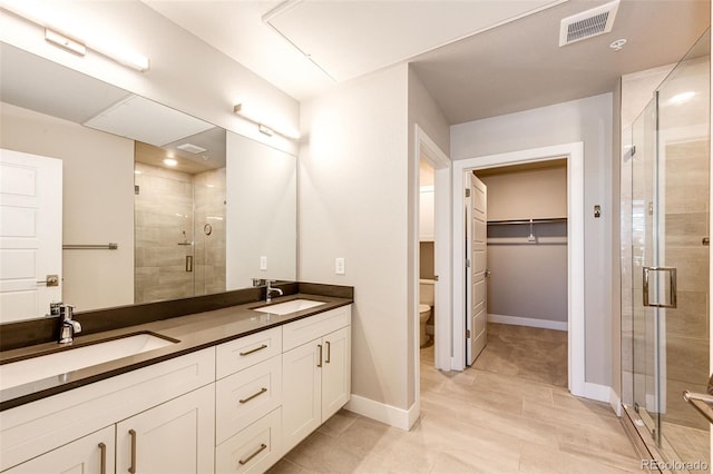 bathroom with toilet, vanity, and walk in shower