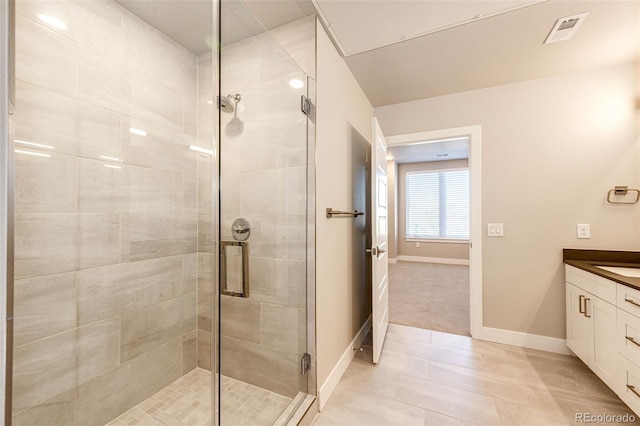 bathroom featuring tile patterned flooring, vanity, and a shower with shower door