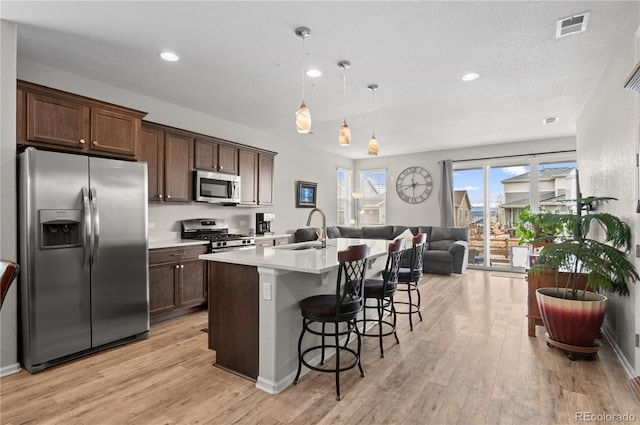 9883 Truckee St, Commerce City, CO 80022 - kitchen featuring a sink, open floor plan, light wood-type flooring, and appliances with stainless steel finishes