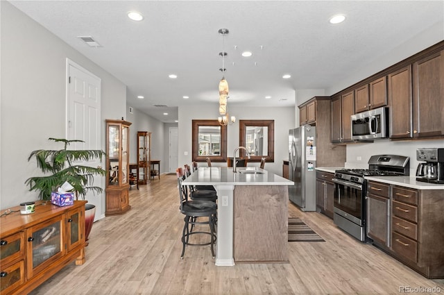 9883 Truckee St, Commerce City, CO 80022 - kitchen featuring visible vents, a sink, light countertops, stainless steel appliances, and light wood-style flooring