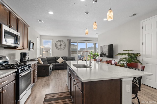 9883 Truckee St, Commerce City, CO 80022 - kitchen with open floor plan, visible vents, a sink, and appliances with stainless steel finishes