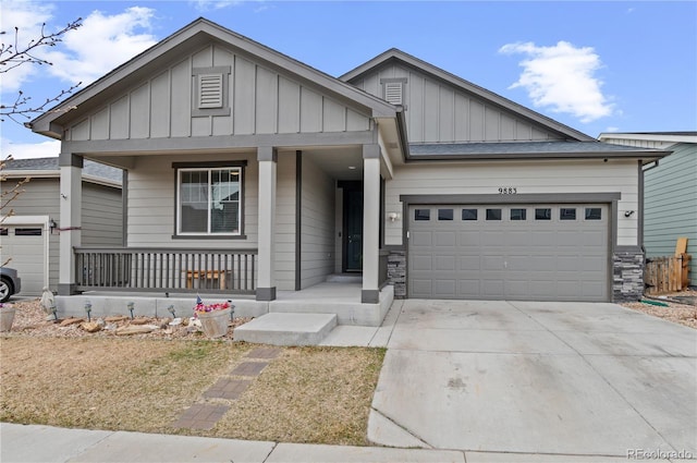 9883 Truckee St, Commerce City, CO 80022 - view of front facade featuring board and batten siding, a porch, a garage, and concrete driveway