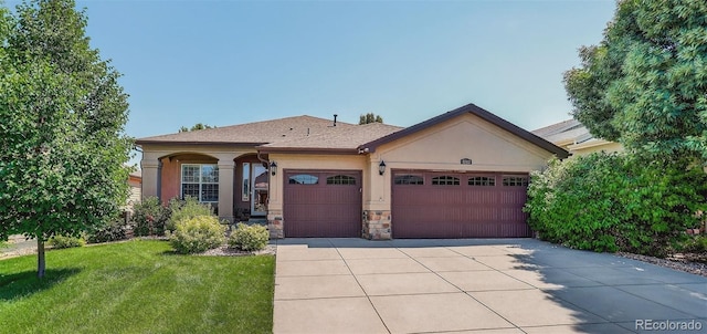 8582 E 148th Ln, Thornton, CO 80602 - view of front facade featuring a garage, stucco siding, concrete driveway, a front yard, and stone siding