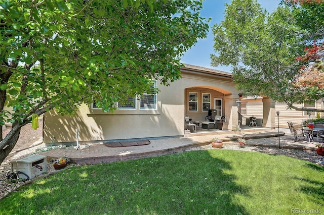 8582 E 148th Ln, Thornton, CO 80602 - back of property with stucco siding, a lawn, and a patio