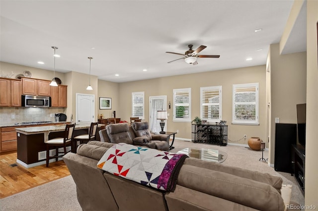 8582 E 148th Ln, Thornton, CO 80602 - living room featuring light carpet, plenty of natural light, a ceiling fan, and recessed lighting