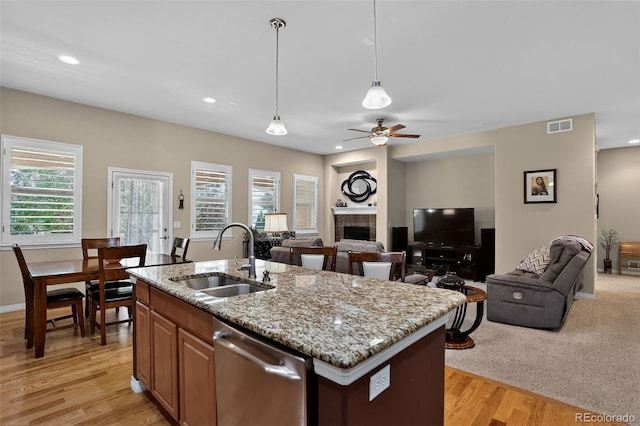 8582 E 148th Ln, Thornton, CO 80602 - kitchen with stainless steel dishwasher, open floor plan, pendant lighting, light wood finished floors, and light stone countertops