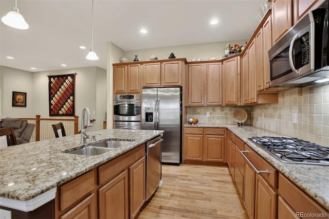 8582 E 148th Ln, Thornton, CO 80602 - kitchen with appliances with stainless steel finishes, light wood-type flooring, hanging light fixtures, backsplash, and light stone counters