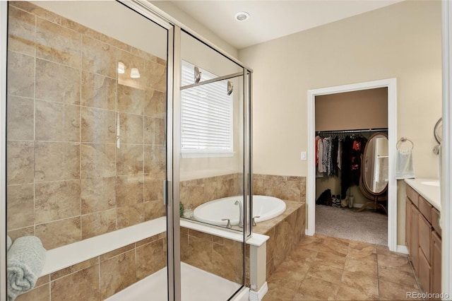 8582 E 148th Ln, Thornton, CO 80602 - full bathroom with vanity, a garden tub, a shower stall, and a walk in closet