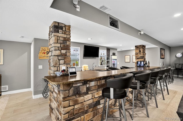 8582 E 148th Ln, Thornton, CO 80602 - bar featuring ornate columns, light wood-type flooring, and recessed lighting