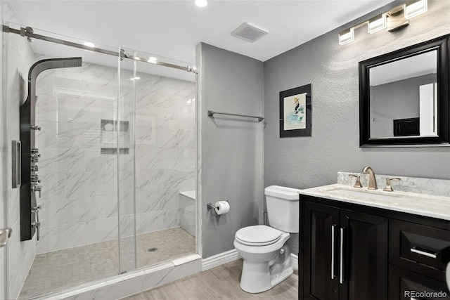 8582 E 148th Ln, Thornton, CO 80602 - bathroom featuring vanity, wood finished floors, a stall shower, and a textured wall