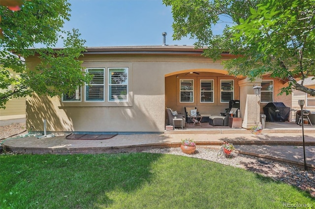 8582 E 148th Ln, Thornton, CO 80602 - back of property with stucco siding, a patio, outdoor lounge area, and a lawn