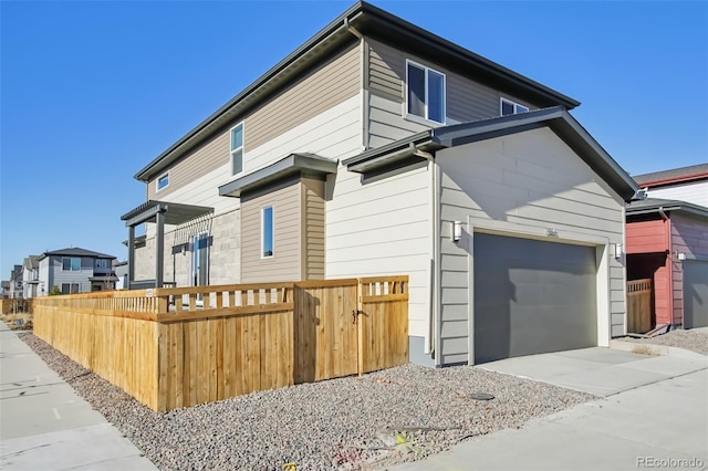 view of side of home with fence and concrete driveway