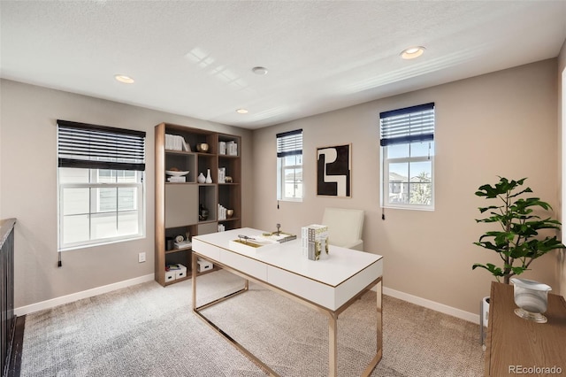 carpeted home office featuring a textured ceiling