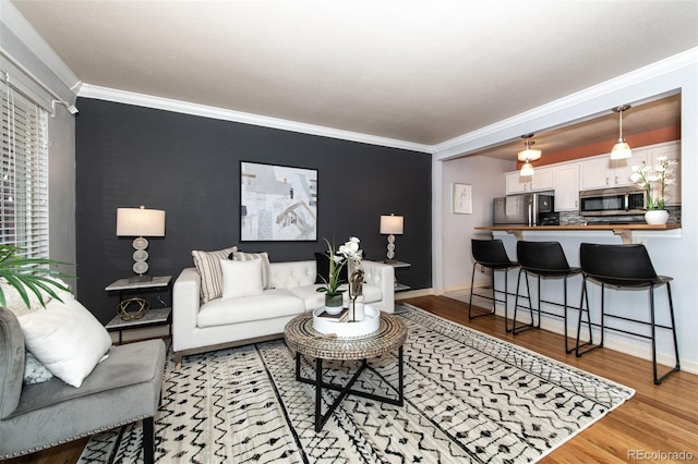 living room with crown molding and light hardwood / wood-style floors