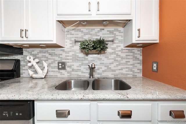 kitchen with backsplash, light stone countertops, white cabinetry, and sink