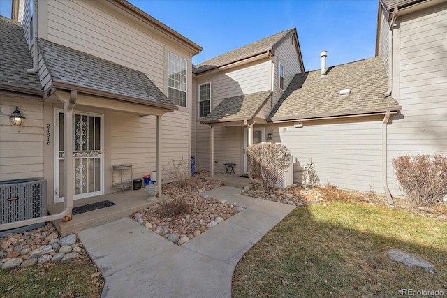 rear view of property with cooling unit and a lawn