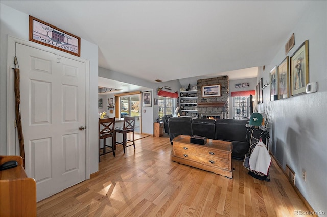 interior space with light hardwood / wood-style floors and a stone fireplace