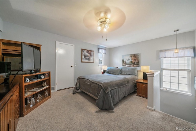 carpeted bedroom with multiple windows and ceiling fan