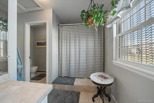 bathroom with tile patterned flooring, curtained shower, and toilet