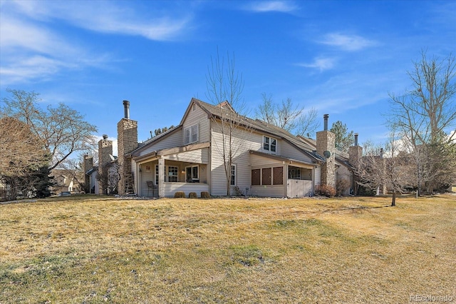 rear view of property with a yard