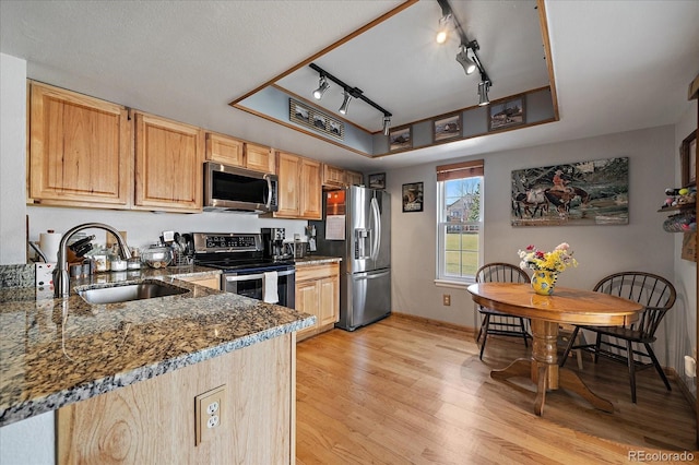 kitchen featuring sink, light brown cabinets, dark stone countertops, and appliances with stainless steel finishes