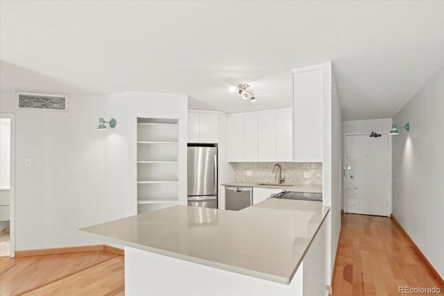 550 E 12th Ave Unit 209, Denver, CO 80203 - kitchen featuring appliances with stainless steel finishes, a sink, white cabinets, and light wood finished floors