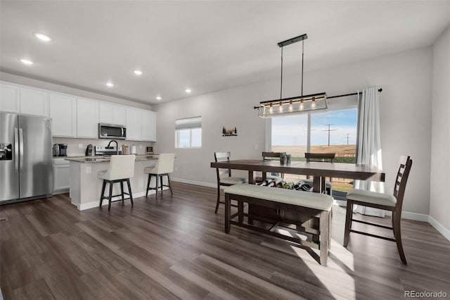 dining room with sink and dark wood-type flooring