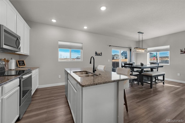 kitchen featuring sink, white cabinets, a center island with sink, and appliances with stainless steel finishes