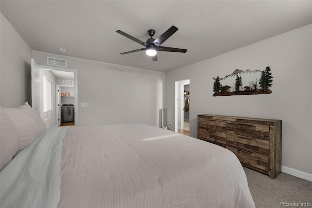 carpeted bedroom featuring ceiling fan, a spacious closet, and a textured ceiling