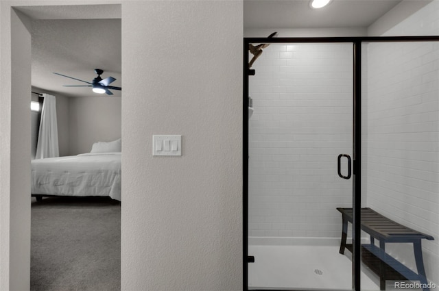 bathroom featuring a textured ceiling, ceiling fan, and a shower with shower door