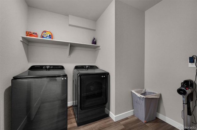 laundry room with independent washer and dryer and dark wood-type flooring