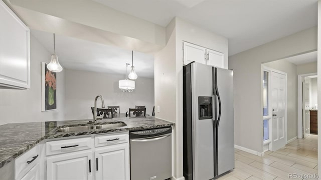 kitchen with decorative light fixtures, white cabinets, appliances with stainless steel finishes, and sink