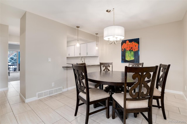 dining space with sink and an inviting chandelier