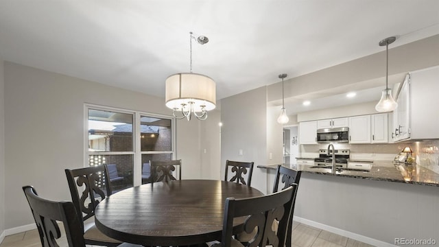 dining space featuring sink and a chandelier