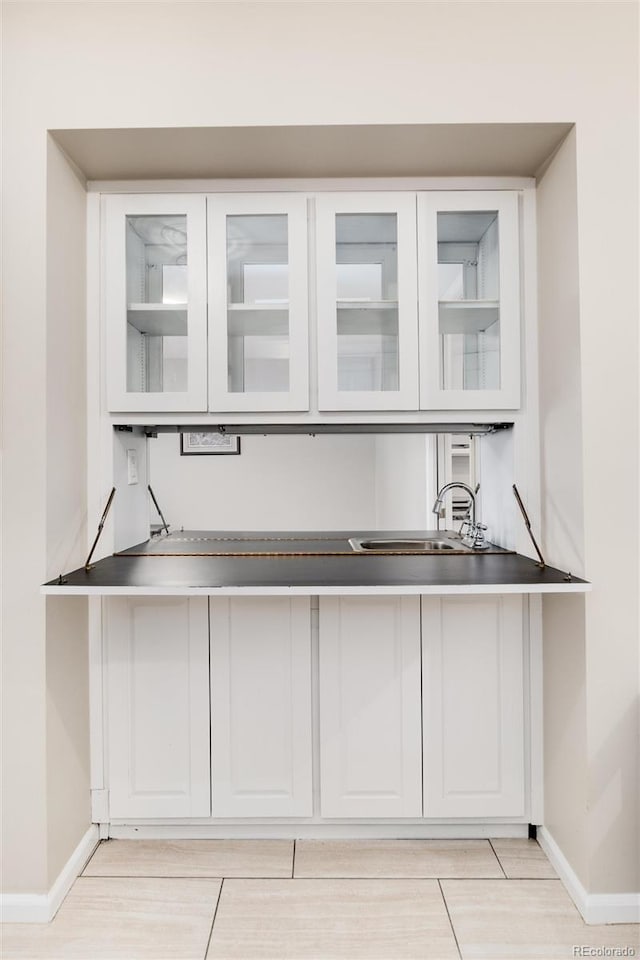 bar with sink and white cabinetry