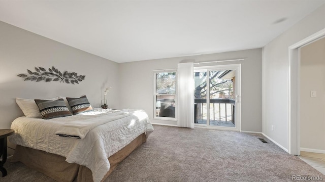 bedroom featuring access to exterior and light carpet