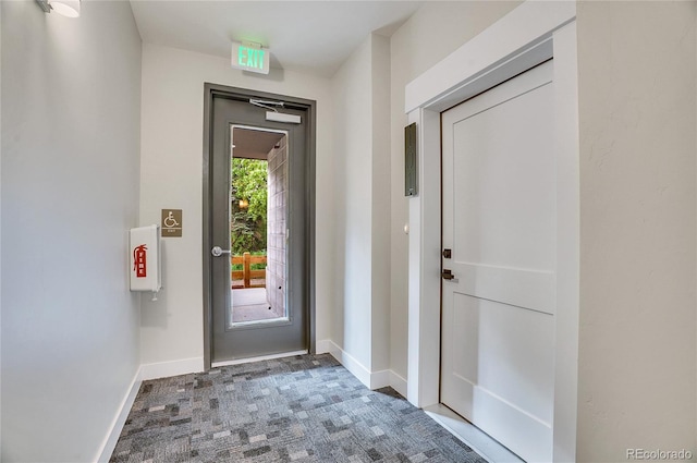 1304 Snowberry Unit 103, Louisville, CO 80027 - doorway to outside featuring baseboards and carpet flooring