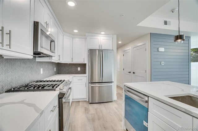 1304 Snowberry Unit 103, Louisville, CO 80027 - kitchen with visible vents, white cabinets, recessed lighting, stainless steel appliances, and light wood-style flooring