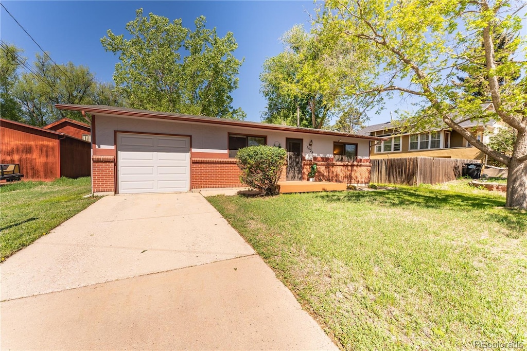 1528 N Chestnut St, Colorado Springs, CO 80907 - view of front facade with brick siding, an attached garage, and concrete driveway