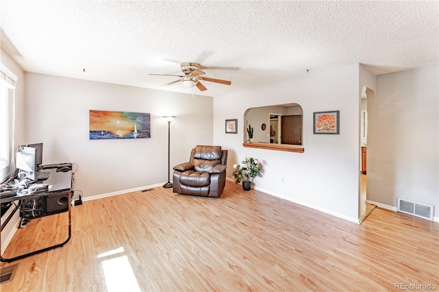 1528 N Chestnut St, Colorado Springs, CO 80907 - living area with a ceiling fan, wood finished floors, arched walkways, a textured ceiling, and baseboards