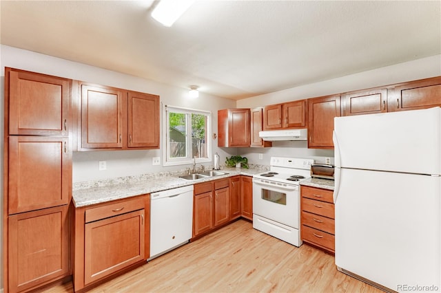 1528 N Chestnut St, Colorado Springs, CO 80907 - kitchen with white appliances, under cabinet range hood, a sink, light wood-type flooring, and brown cabinetry