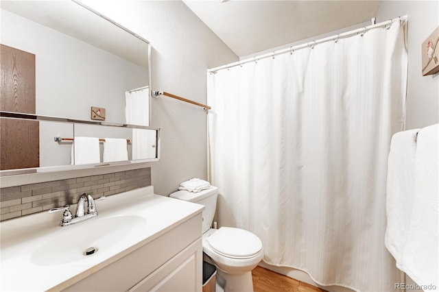 1528 N Chestnut St, Colorado Springs, CO 80907 - full bathroom with decorative backsplash, vanity, toilet, and wood finished floors